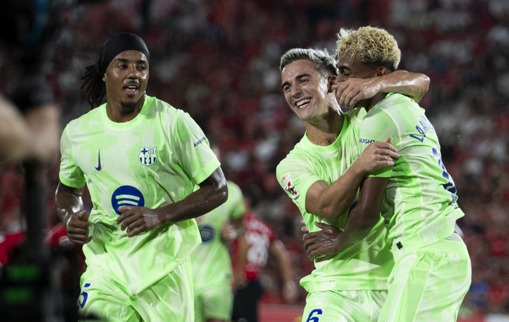 El delantero español #10 del Barcelona, ​​Lamine Yamal (R), celebra el tercer gol de su equipo con el centrocampista español #06 del Barcelona, ​​Pablo Gavi, durante el partido de fútbol de la liga española entre el RCD Mallorca y el FC Barcelona en el Estadio Mallorca Son Moix en Palma de Mallorca el 16 de agosto de 2025. (Foto de JAIME REINA / AFP)