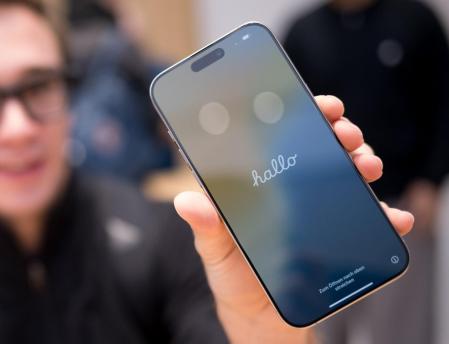 20 September 2024, Berlin: Daniel holds his new iPhone 16 in an Apple store. Apple is focusing on better cameras and artificial intelligence in its new iPhones. However, users in the European Union will not initially experience many of the new AI functions. Photo: Sebastian Christoph Gollnow/dpa