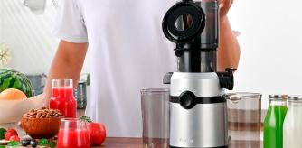 Un hombre preparando un zumo de manzana con su extractor